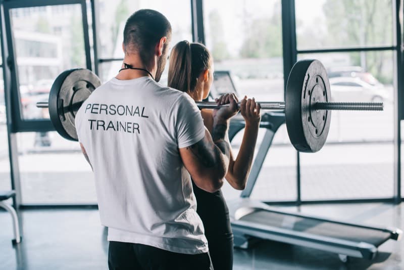 Personal trainer che segue un allenamento individuale